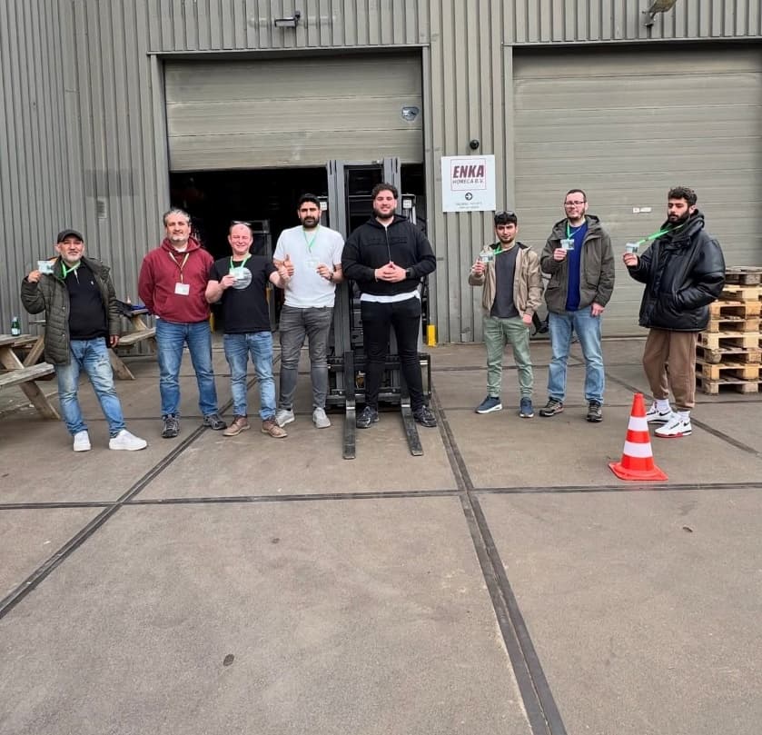 Deelnemers van een incompanytraining poseren na afloop bij het bedrijfspand